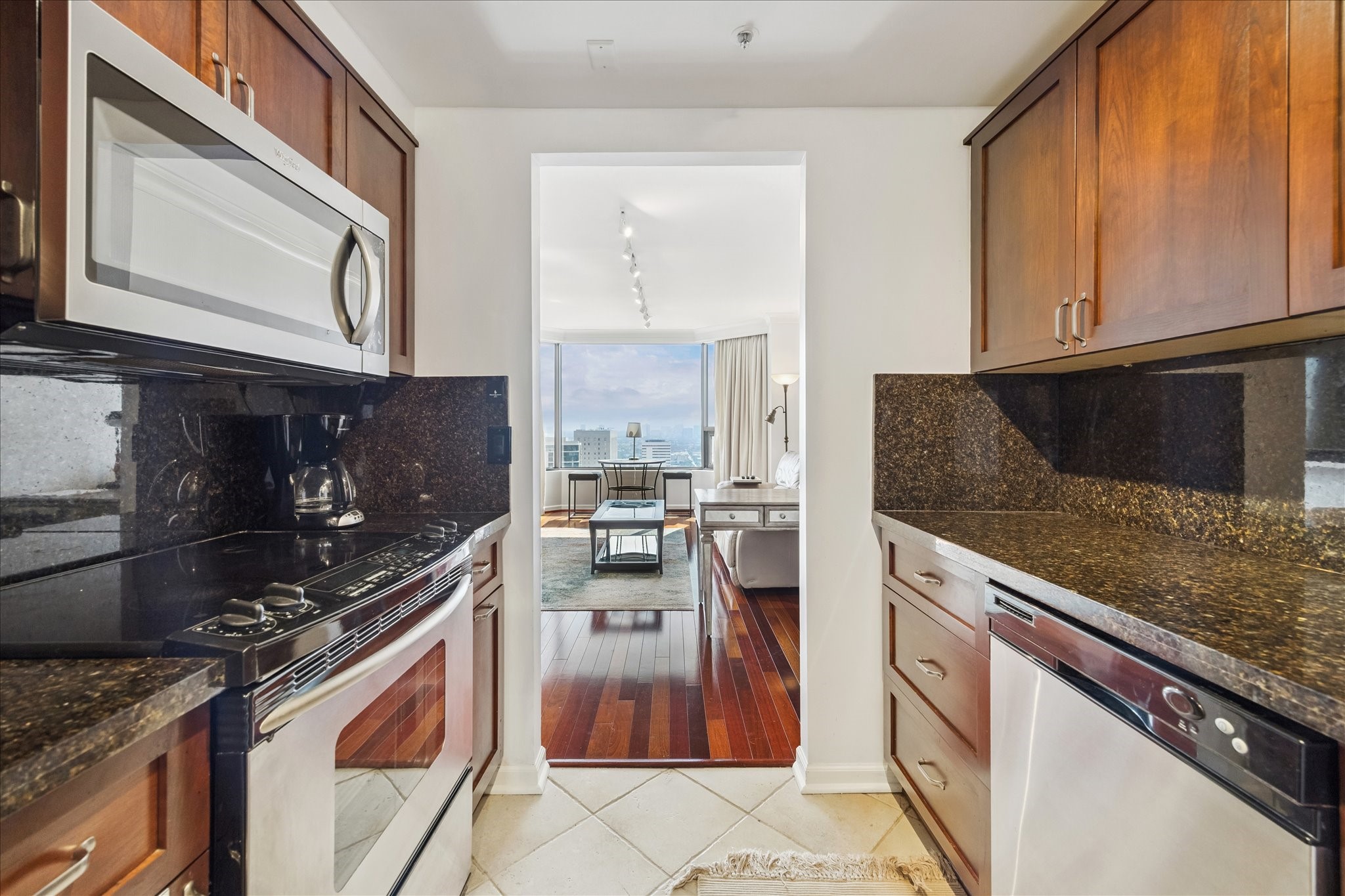 1111 Caroline Street, Unit 2908 Houston, TX 77010 - Photo 9 of 50 a kitchen with stainless steel appliances granite countertop a stove a sink and a microwave