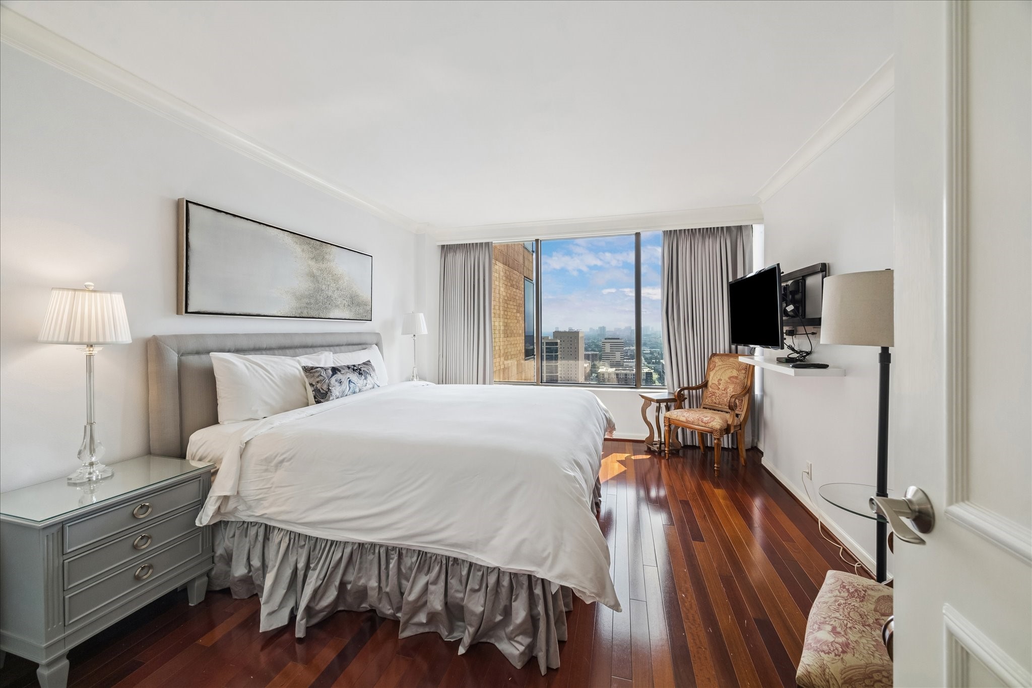 1111 Caroline Street, Unit 2908 Houston, TX 77010 - Photo 10 of 50 a bedroom with a bed and a flat tv screen on the dresser