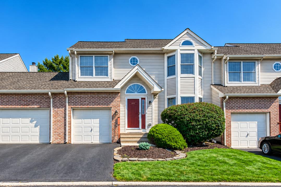 Traditional brick and siding accents define this townhome exterior with an attached garage.