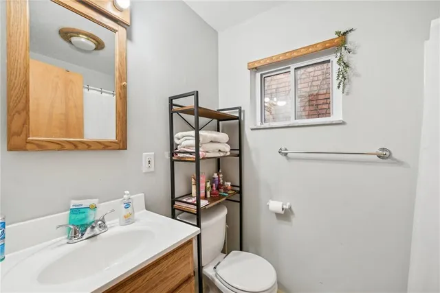 a bathroom with a sink vanity mirror and toilet