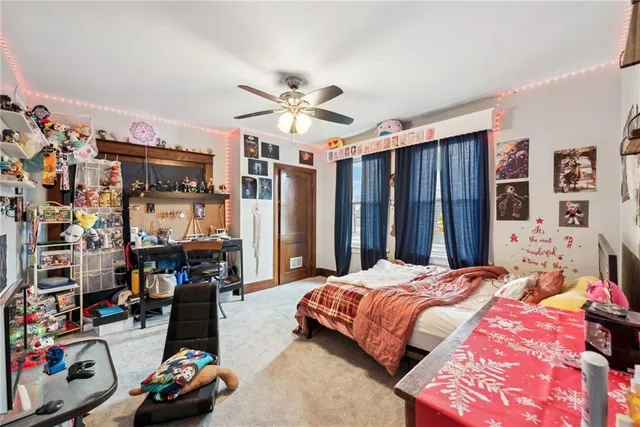 a bedroom with a bed a standing and a bookshelf