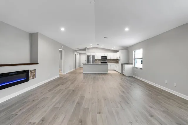 a view of a kitchen with furniture and wooden floor