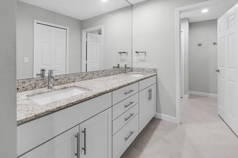 a bathroom with double sink and a mirror