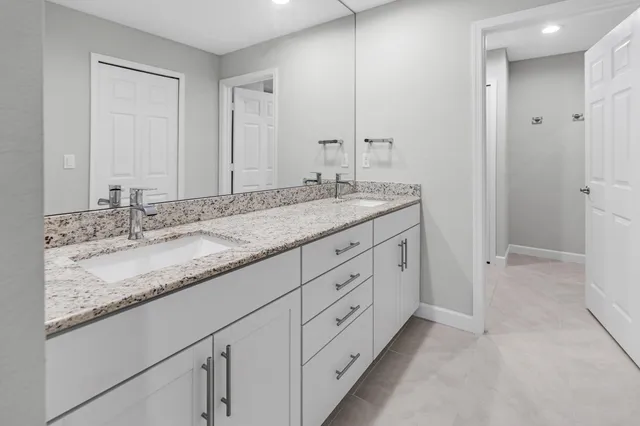 a bathroom with double sink and a mirror