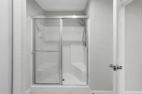 a bathroom with a glass shower door