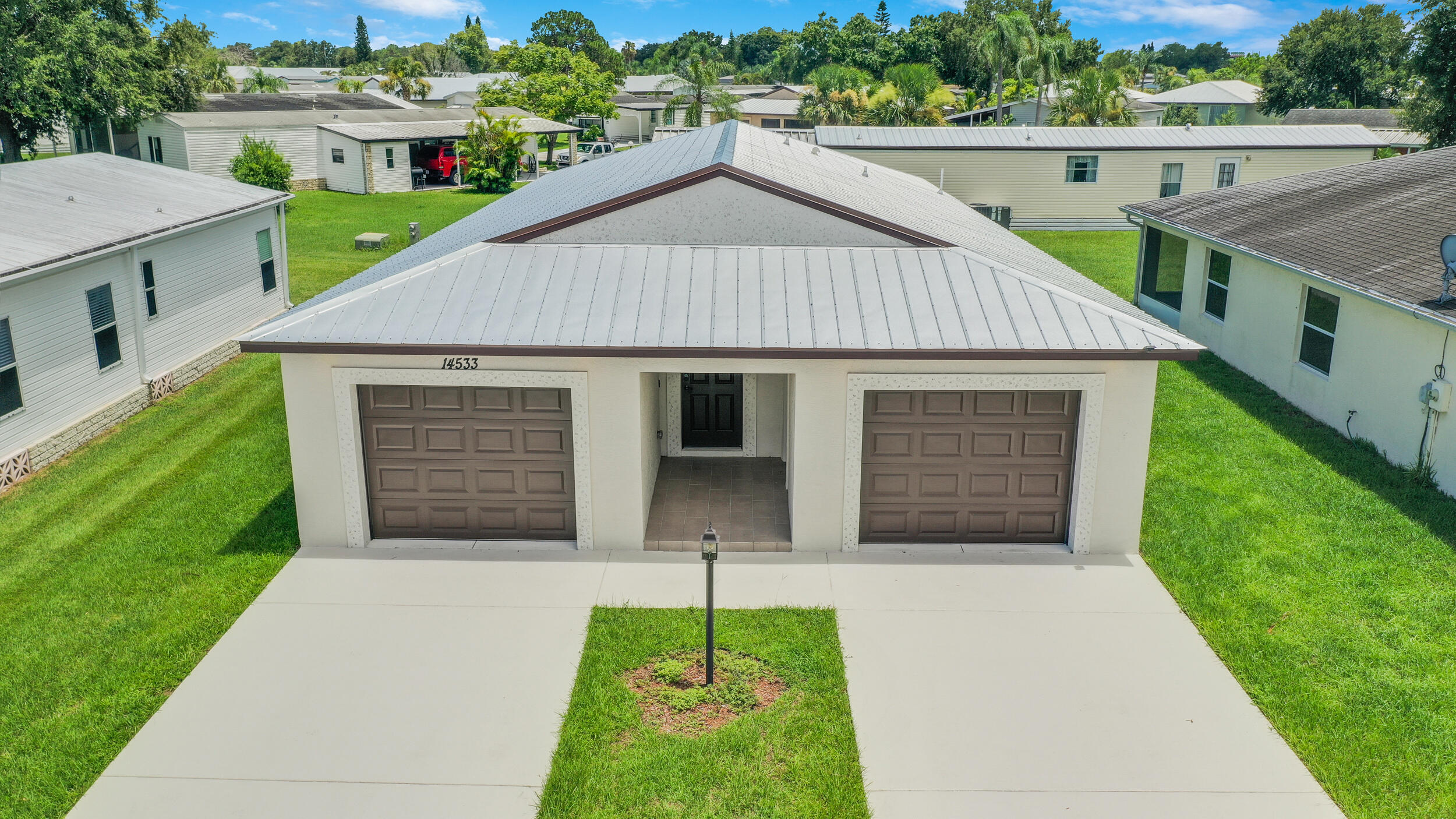 14533 Dulce Real Avenue Fort Pierce, FL 34951 - Photo 37 of 42 a front view of a house with a yard and garage
