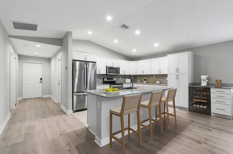 a kitchen with refrigerator and chairs