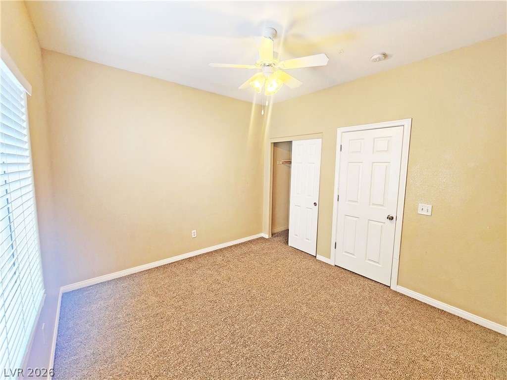 1421 Star Road, Unit 2 Pahrump, NV 89048 - Photo 16 of 33 Unfurnished bedroom featuring carpet floors, a ceiling fan, baseboards, and a closet