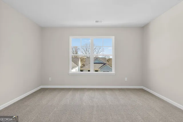 a view of an empty room with closet and a window