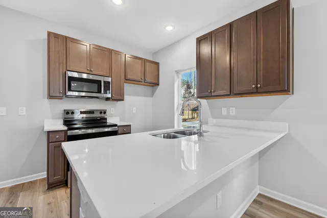 a kitchen with stainless steel appliances granite countertop a sink stove and microwave