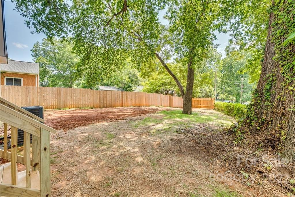 1321 Enderly Road Charlotte, NC 28208 - Photo 23 of 26 a view of a backyard with large trees and wooden fence