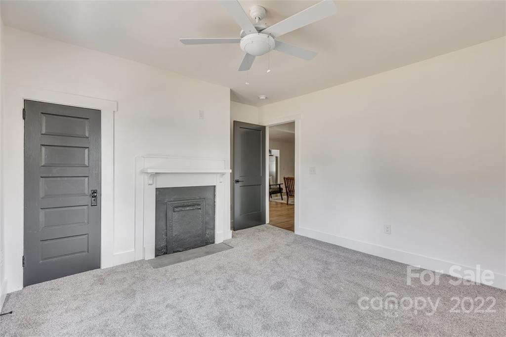 1321 Enderly Road Charlotte, NC 28208 - Photo 9 of 26 an empty room with a fireplace and fan