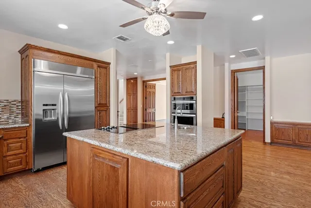a kitchen with stainless steel appliances granite countertop a sink and a refrigerator