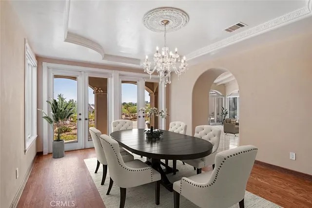 a dining room with furniture potted plants and wooden floor