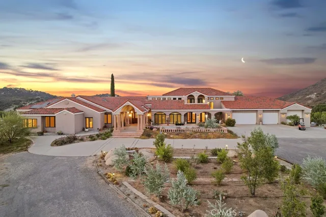 a view of a big house with a big yard and large tree
