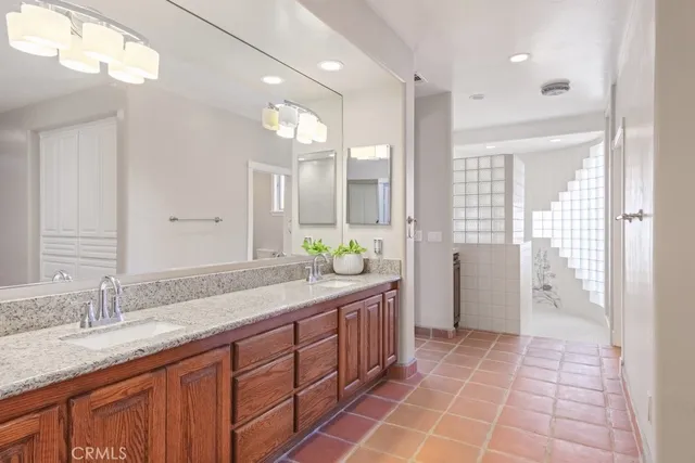 a spacious bathroom with a granite countertop sink and a mirror