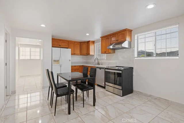 a kitchen with stainless steel appliances granite countertop a stove a sink a microwave and a refrigerator