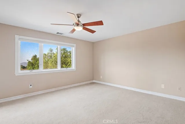 an empty room with ceiling fan and window