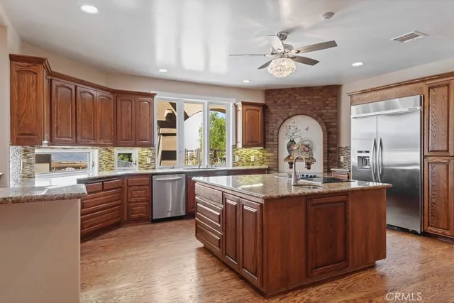 a kitchen with stainless steel appliances granite countertop a sink a stove and refrigerator