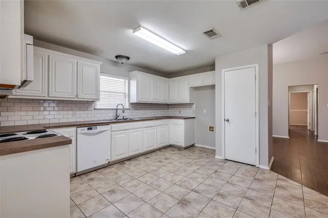 a kitchen with granite countertop a sink cabinets and stainless steel appliances