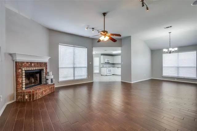 a view of a livingroom with wooden floor a fireplace and window