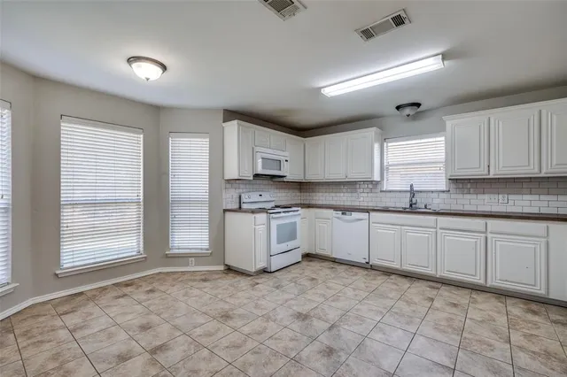 a large kitchen with a stove a sink dishwasher and a refrigerator