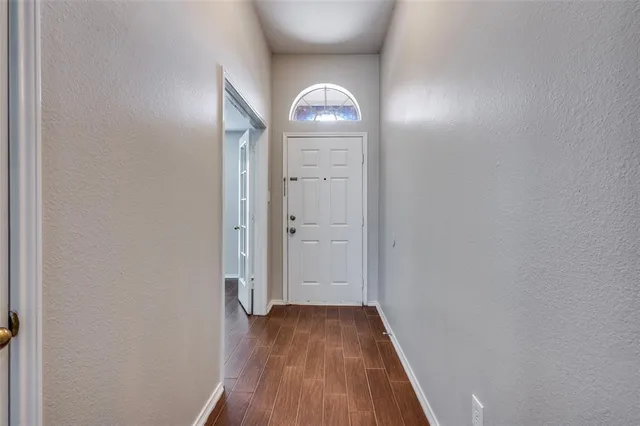 a view of empty room with wooden floor and window