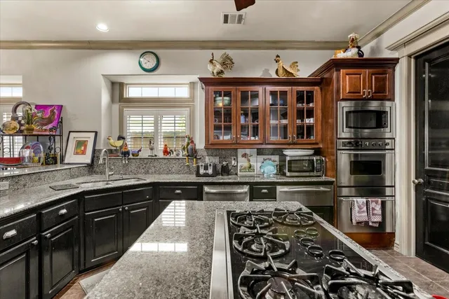 a kitchen with granite countertop stainless steel appliances and wooden cabinets