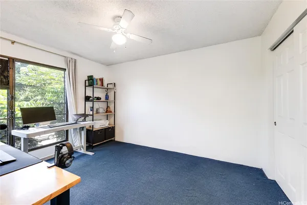 a view of a workspace with furniture and a ceiling fan