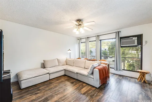 a living room with furniture and a large window with wooden floor