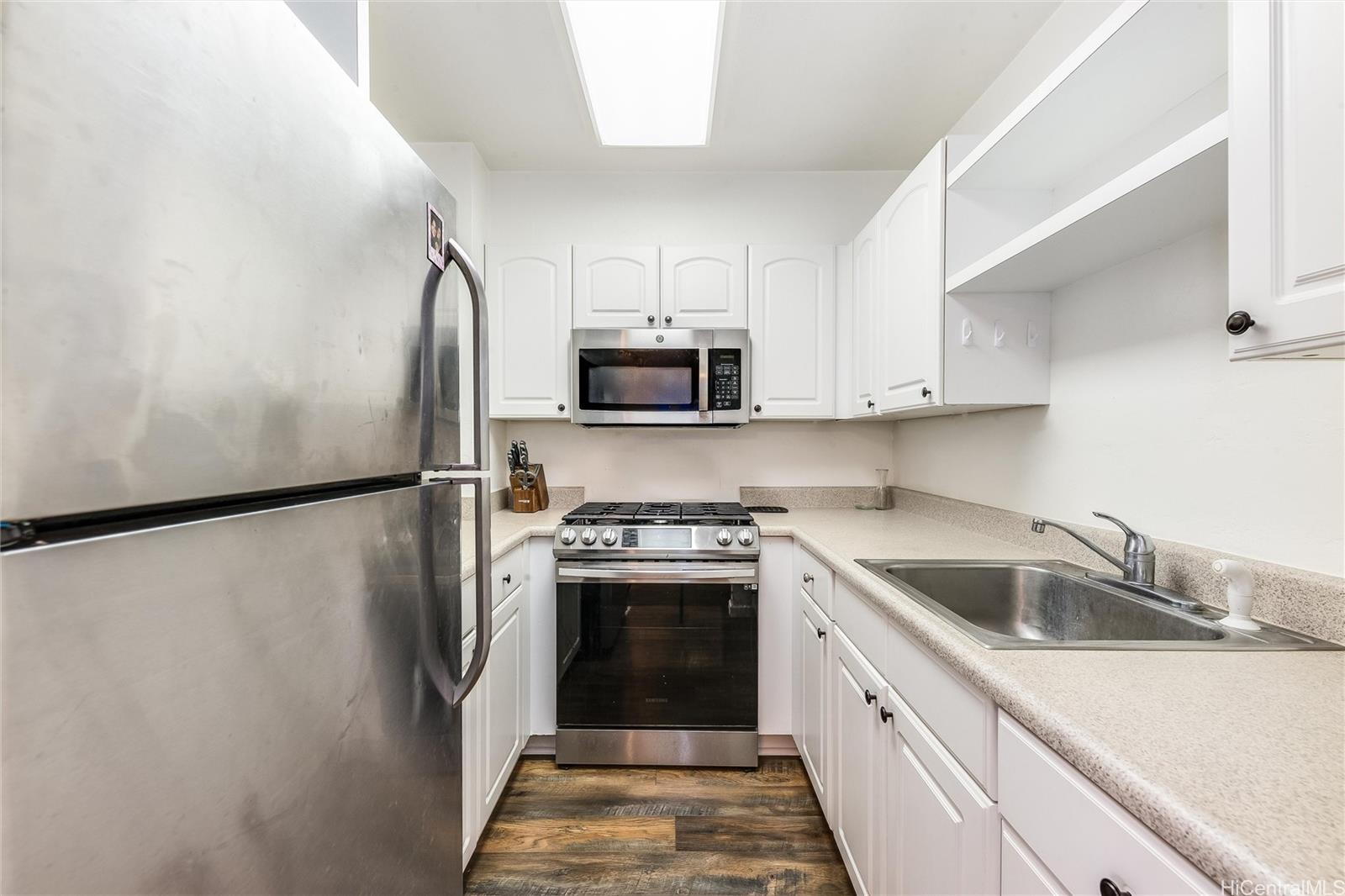 87-119 Helelua Street, Unit F202 Waianae, HI 96792 - Photo 7 of 25 a kitchen with refrigerator a microwave and sink