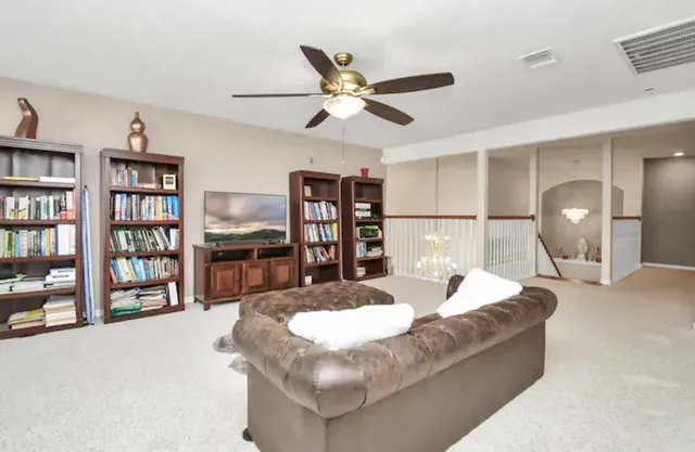 a living room with furniture and a book shelf