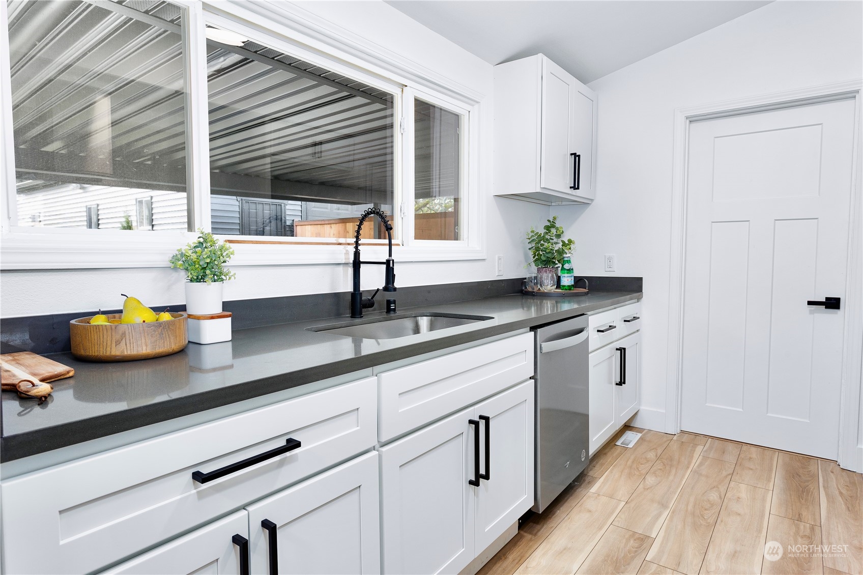 7922 Leschi Road Southwest Tacoma, WA 98498 - Photo 9 of 37 a kitchen with stainless steel appliances white cabinets a potted plant and a window