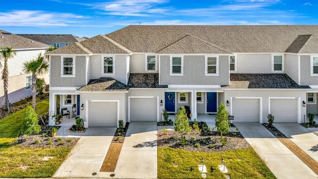 a view of a white house with potted plants in front of it