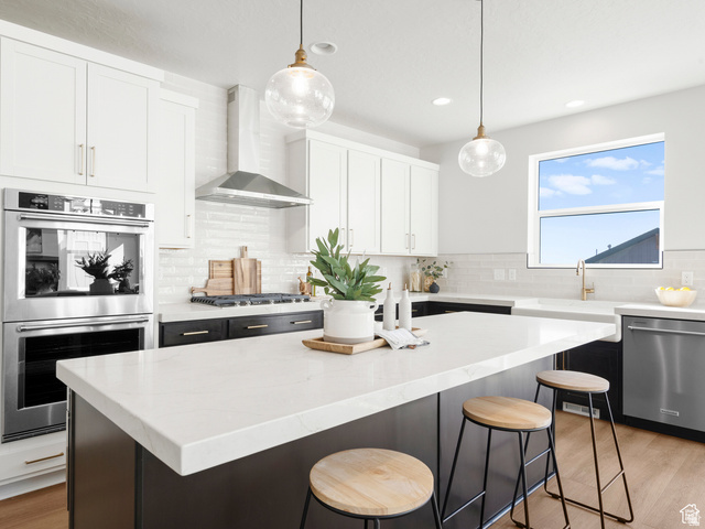 1711 West Canyon Rim Road North Lehi, UT 84048 - Photo 5 of 31 Modern kitchen featuring a large central island with a light-toned countertop, contrasting dark base cabinetry, and wood-finish flooring