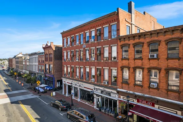 a city street lined with buildings and a yard