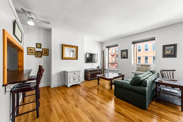 a living room with furniture a wooden floor and a flat screen tv