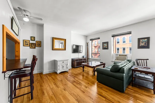 a living room with furniture a wooden floor and a flat screen tv