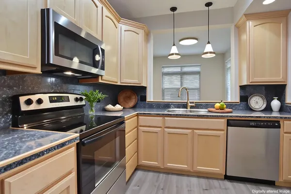 a kitchen with stainless steel appliances granite countertop a sink a stove and a microwave