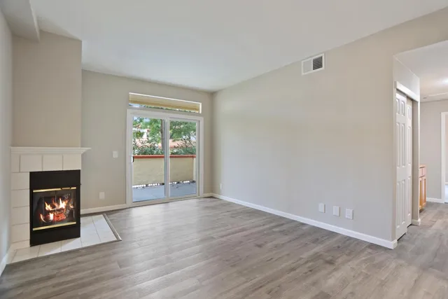 a view of an empty room with window and fire place