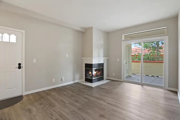 a view of an empty room with window and fire place