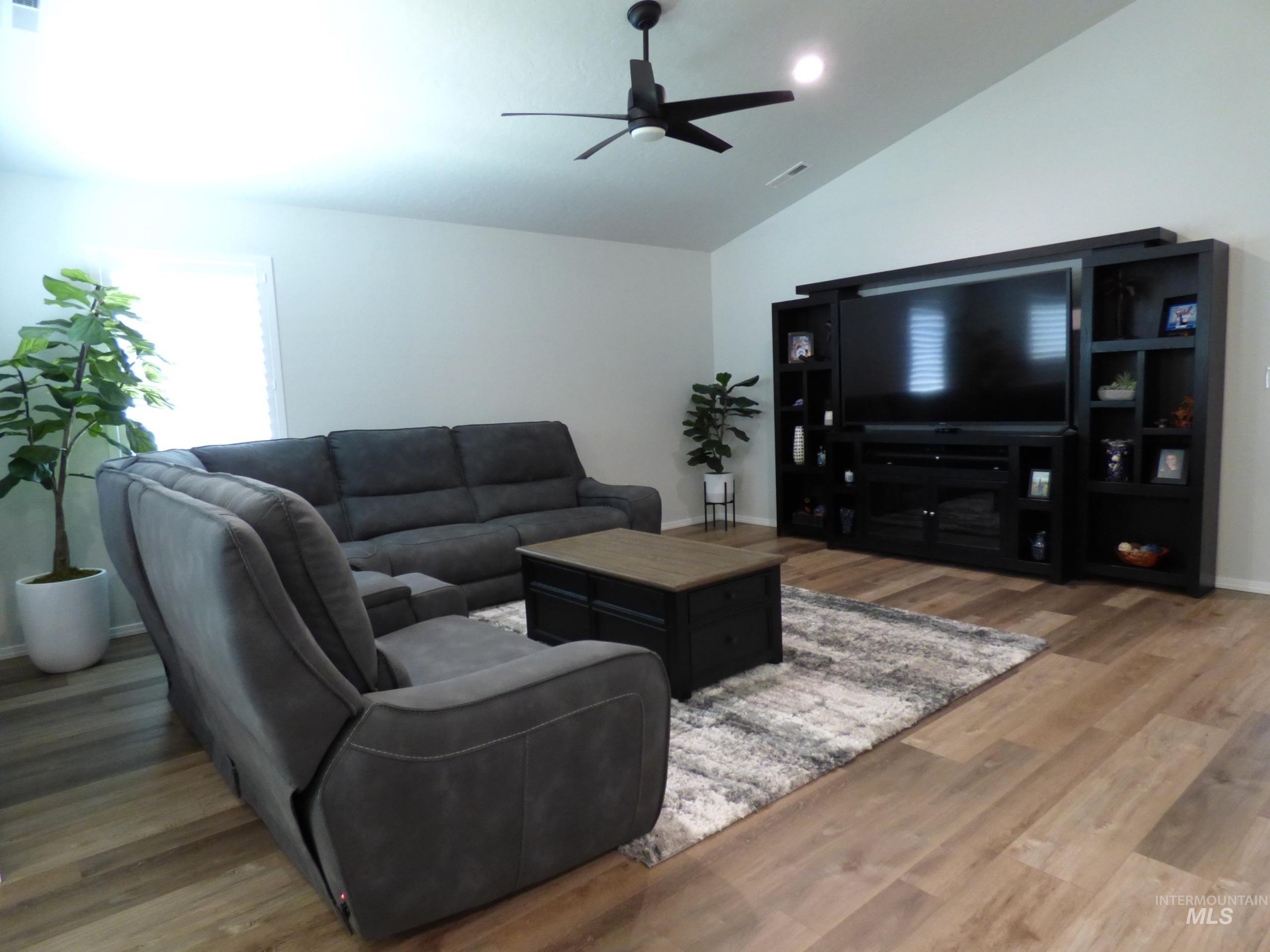 2708 East Buckaroo Drive Kuna, ID 83634 - Photo 12 of 48 Living area featuring vaulted ceilings, wood-finish flooring, a built-in media center, recessed lighting, and a ceiling fan