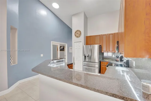 an empty room with kitchen and windows