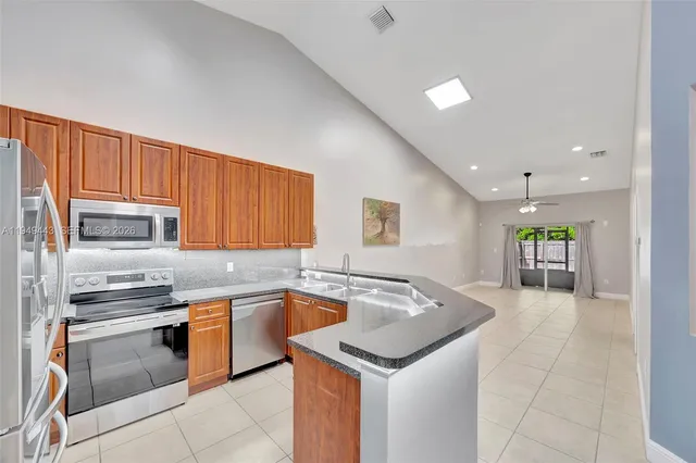 a kitchen with stainless steel appliances granite countertop a sink and dishwasher a stove top oven with wooden floor