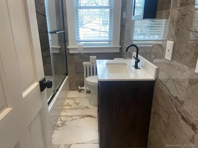 a bathroom with a sink a toilet a mirror and window