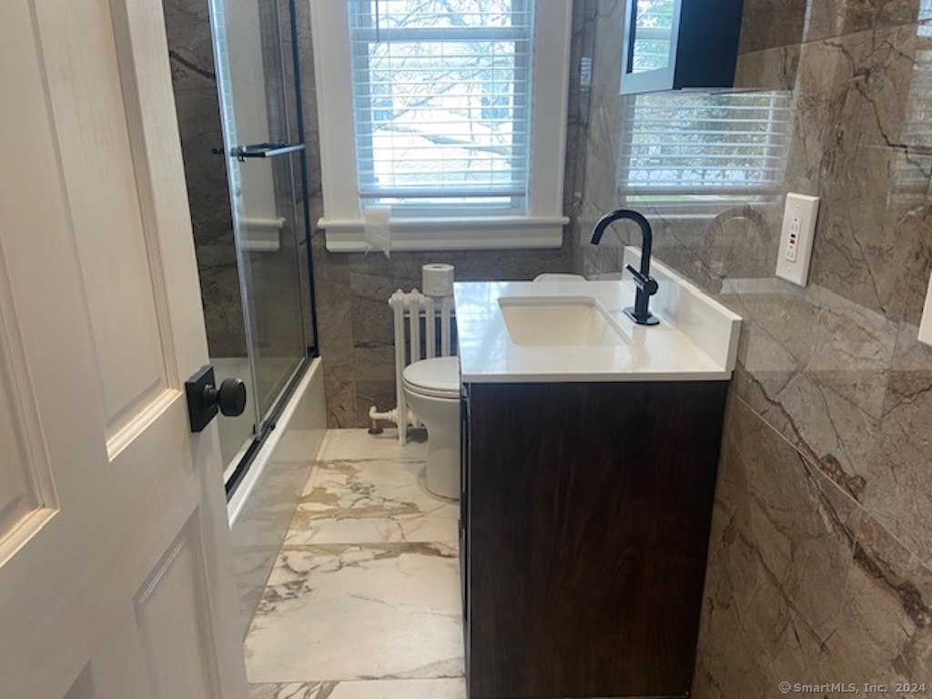 279 Wakelee Avenue Ansonia, CT 06401 - Photo 15 of 23 a bathroom with a sink a toilet a mirror and window