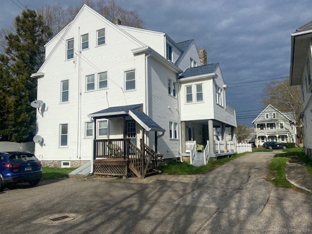 279 Wakelee Avenue Ansonia, CT 06401 - Photo 19 of 23 a view of a white building among the street with parked cars