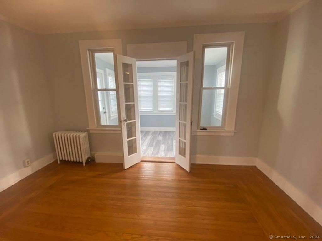 279 Wakelee Avenue Ansonia, CT 06401 - Photo 10 of 23 an empty room with wooden floor and windows