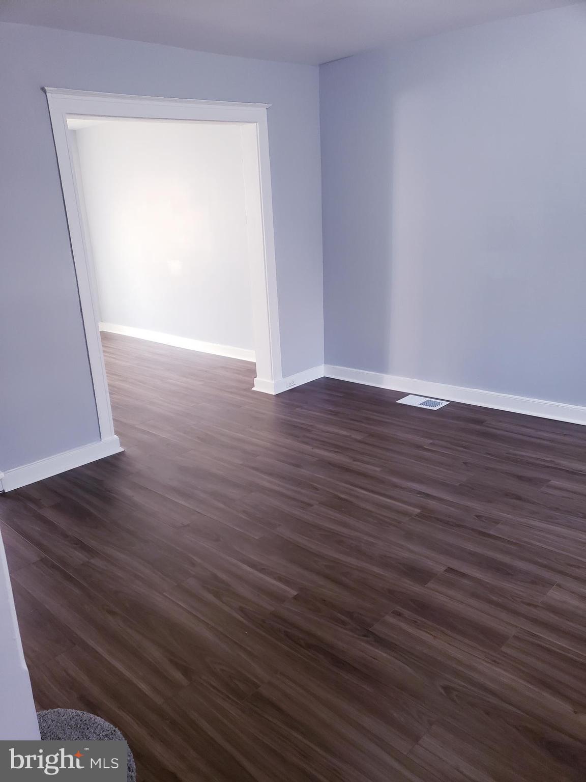 3441 Elmora Avenue Baltimore, MD 21213 - Photo 8 of 10 a view of an empty room with wooden floor and a window