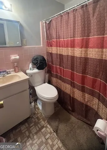 a bathroom with a toilet and a shower curtain